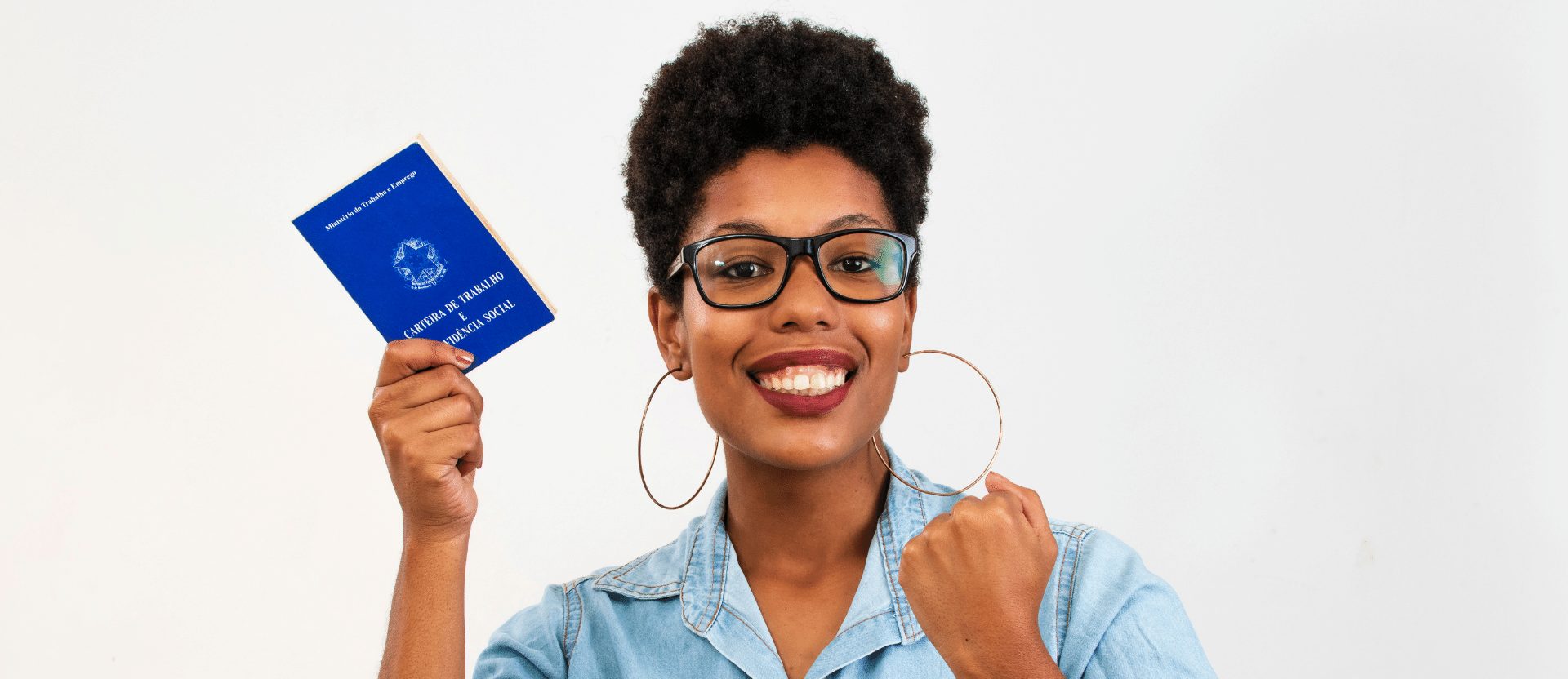 mulher negra segurando uma carteira de trabalho na mão e comemorando